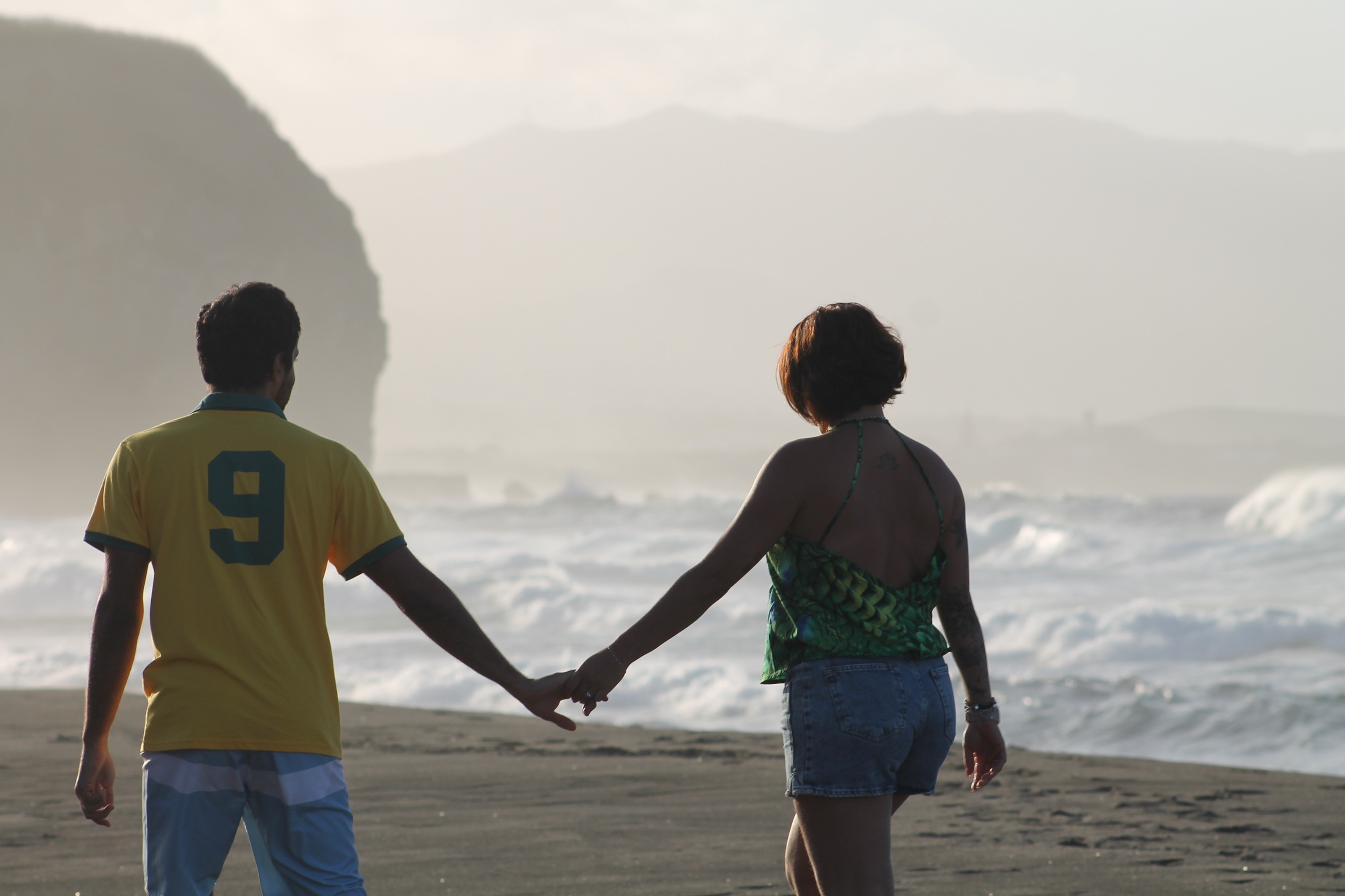 Casal de mãos dadas na praia, silhueta