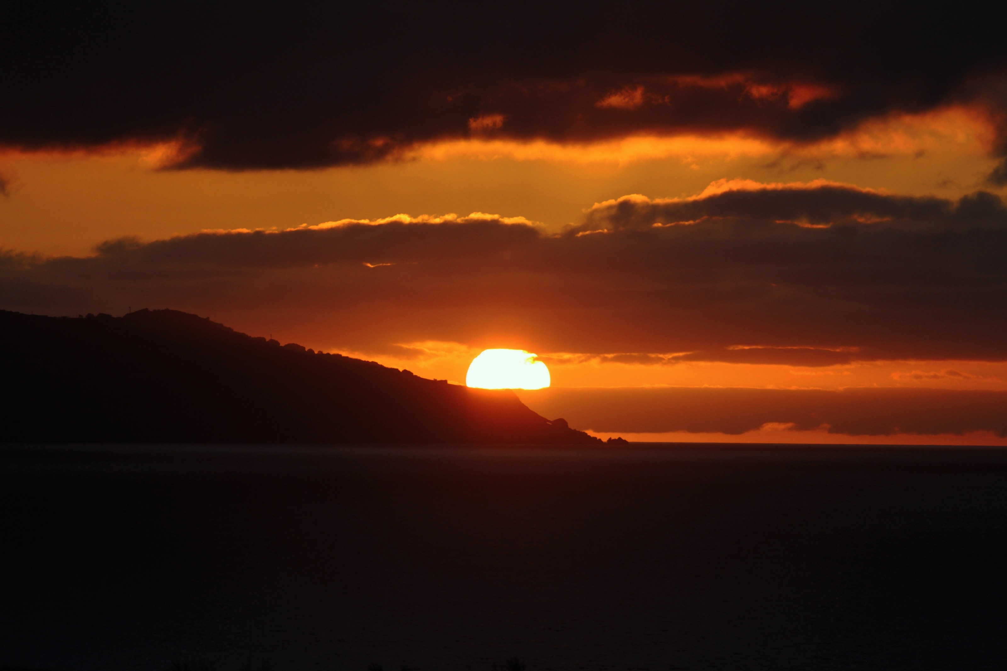 Sol a descer atrás da montanha na costa oeste de São Miguel