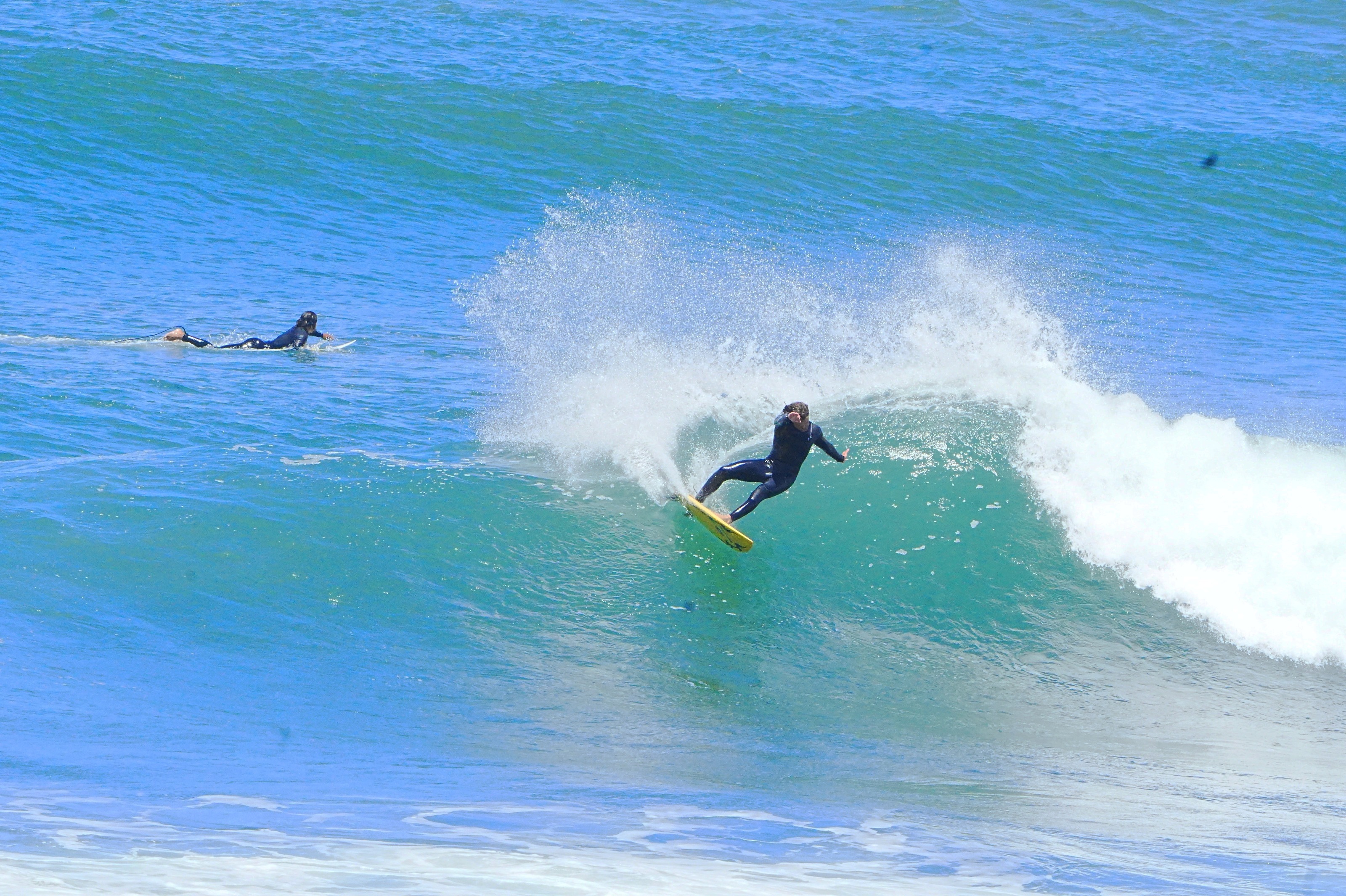 Surfista numa parede de onda turquesa