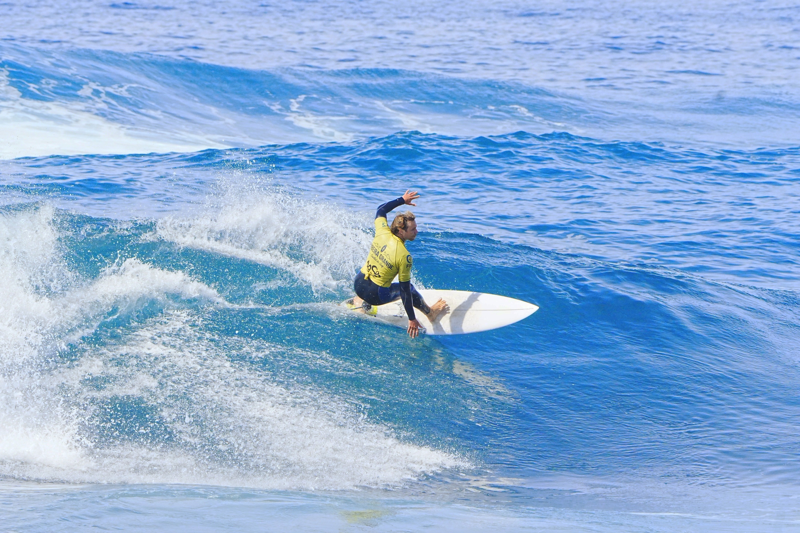 Surfista a descer uma onda azul