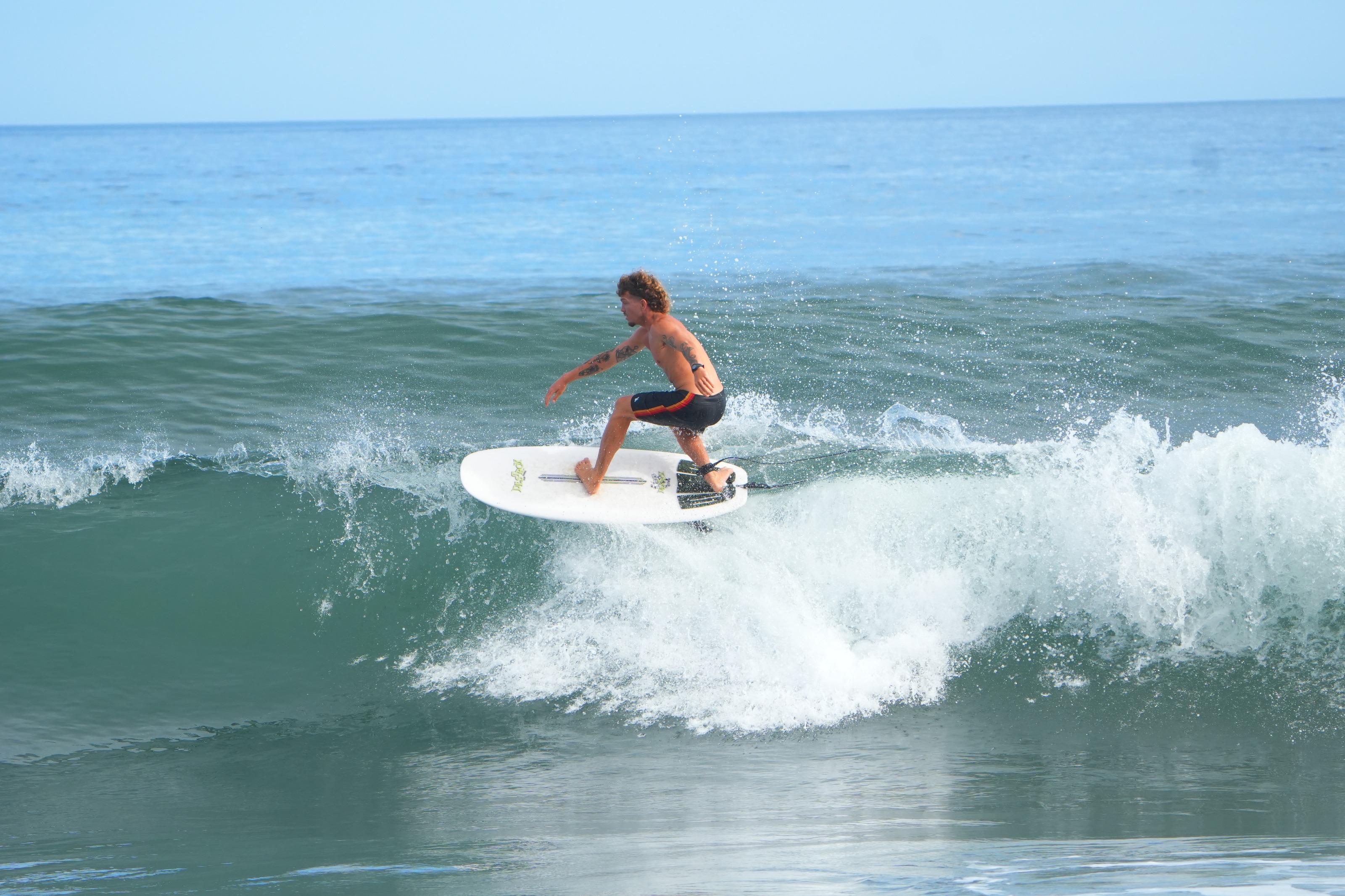 Surfista a ganhar velocidade na base de uma onda verde