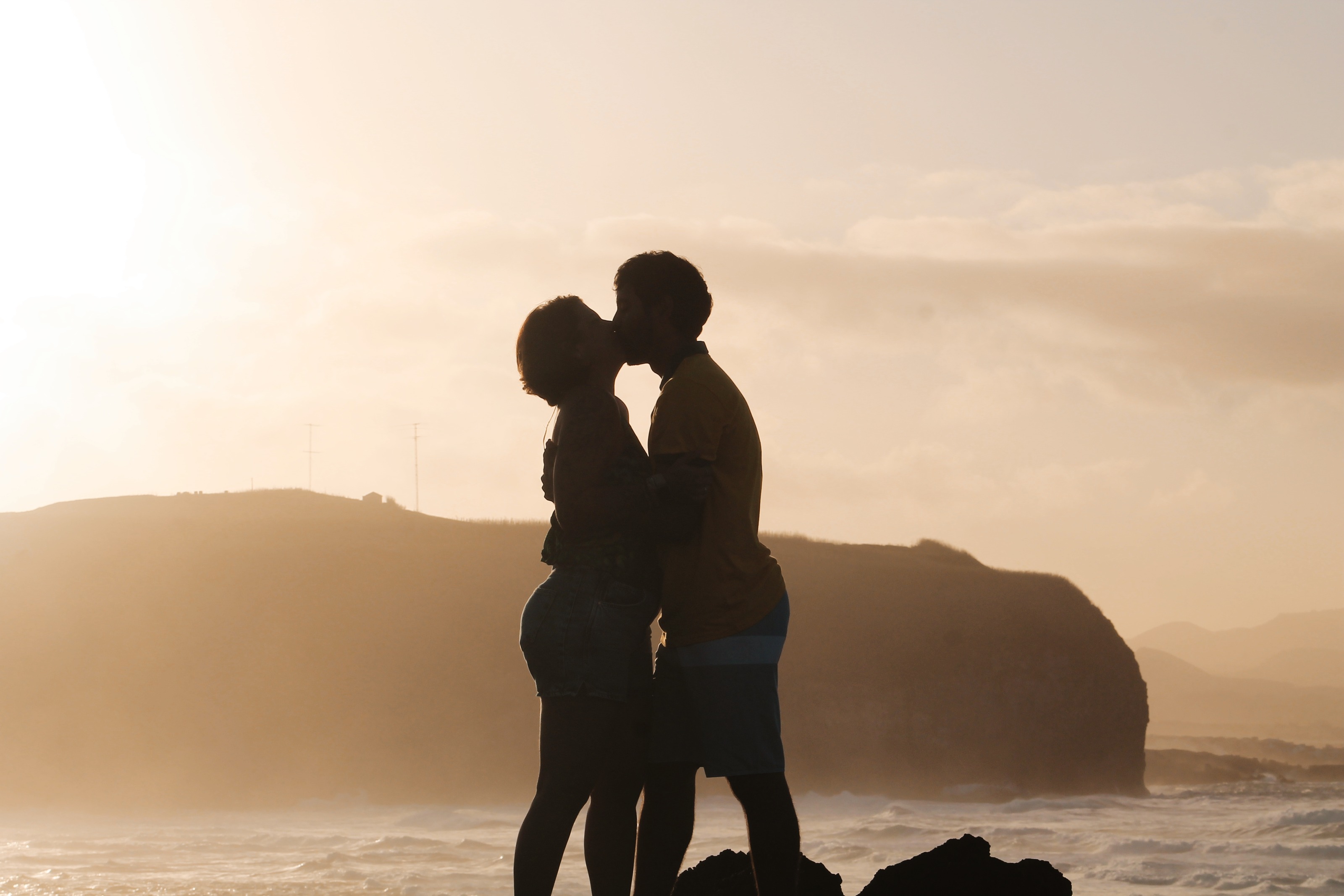 Casal em silhueta ao pôr do sol num spot dos Açores